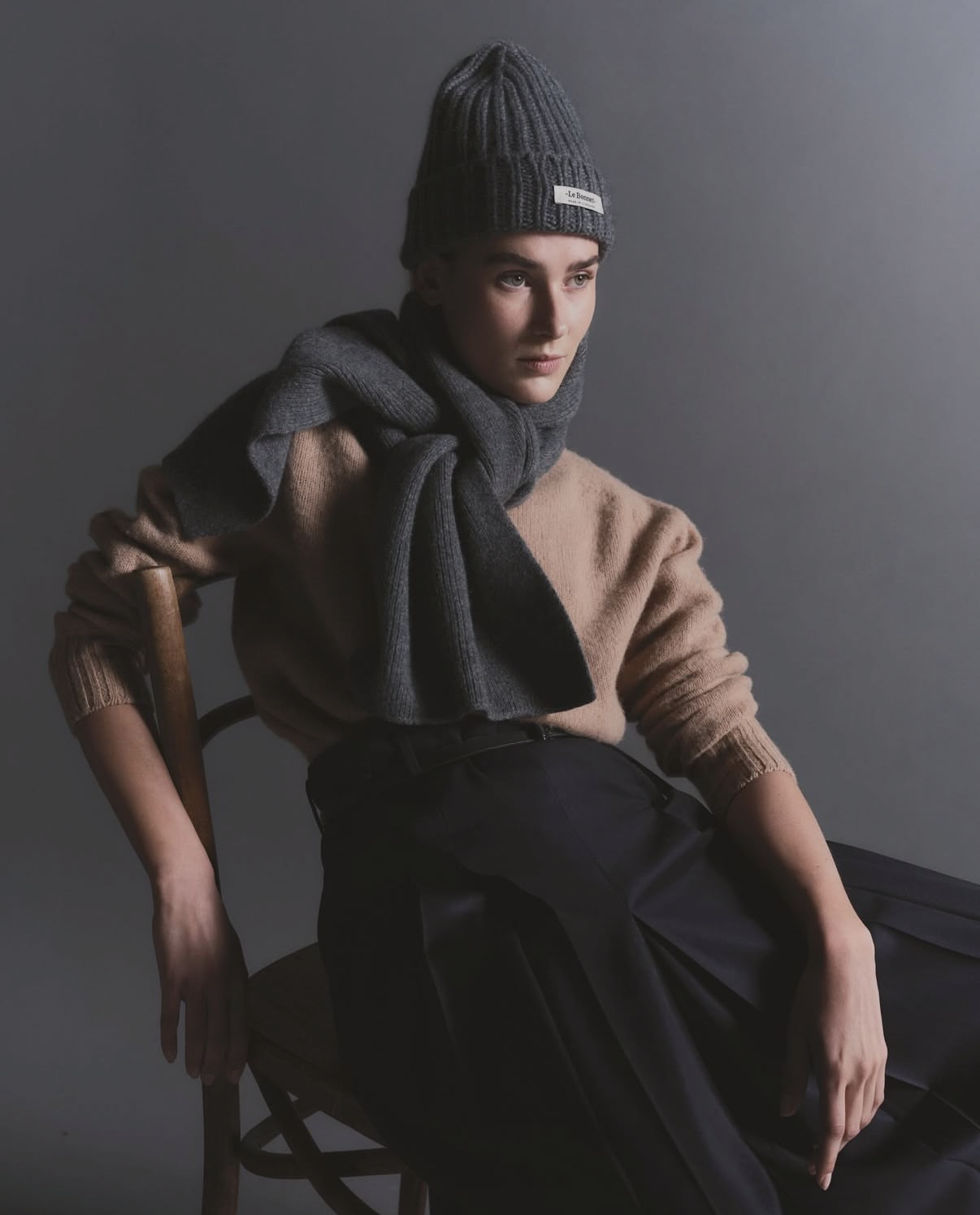 Femme assiseavec un bonnet et une écharpe cool