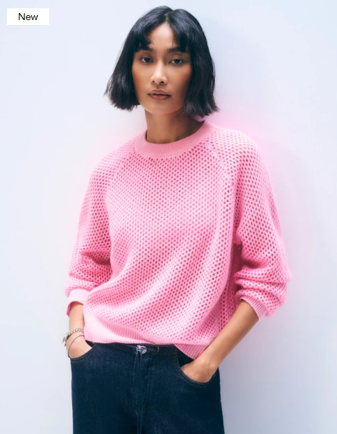 Femme brune portant un pull en maille de cachemire rose et rose fluo de la marque White+Warren