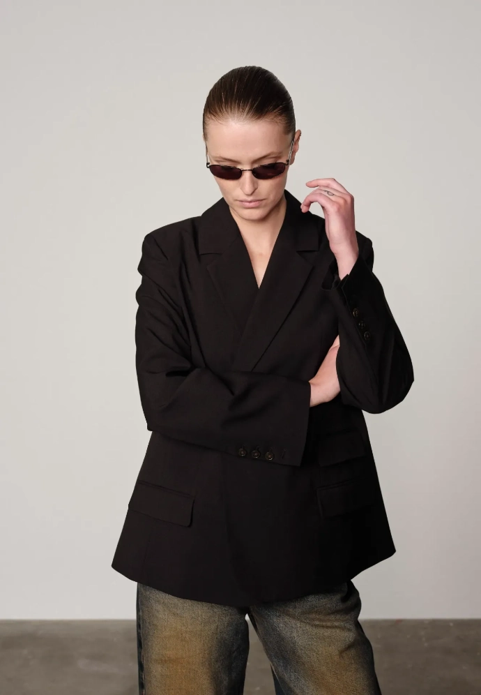 Femme portant un blazer noir sur un jeans