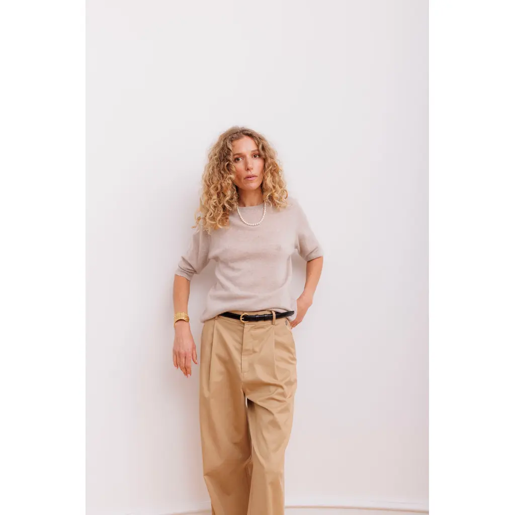 Femme blonde portant un pull beige
